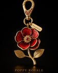 DemmiFalestini Poppy Royale Palestinian poppy bag charm with ruby-red enamel petals, gold-plated stem and leaves, cubic zirconia center and lobster clasp