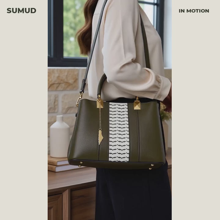 Sumud in motion: Olive Grove worn on the shoulder, opened, packed with a phone, compact wallet and keys, and carried with its detachable strap.